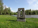 Památník s vytesaným křížem na břehu rybníka Ležák.