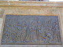 Zadní strana pomníku je ozdobena reliéfem, kde poselstvo přivádí Přemysla Oráče ke kněžně Libuši na Vyšehrad.