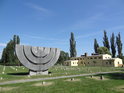 Židovský hřbitov se sedmiramenným svícnem, vpravo krematorium.